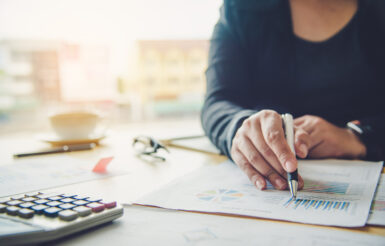 Business people are working on accounts in business analysis with graphs and documentation.